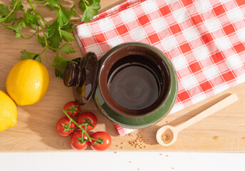 Baking dish on the kitchen table among vegetables and herbs