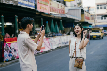 Obraz premium Young happy Asian couple tourist backpackers enjoy traveling in the local market.