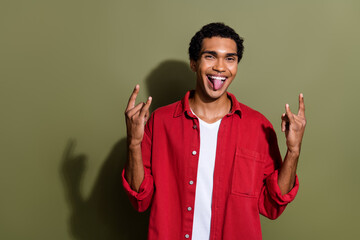 Photo of positive funny man dressed red shirt stick out showing two hard rock signs empty space...