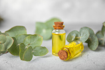 Eucalyptus essential oil in a glass bottle with green eucalyptus leaves on a textured wooden background. Aromatherapy concept. Spa. Natural organic ingredients for cosmetics and body care.Copy space