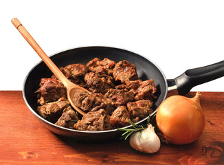 pan with meat stew, wooden table, onion and garlic
