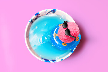 Pink Brain Lounging in Cup Pool with Inflatable Ring