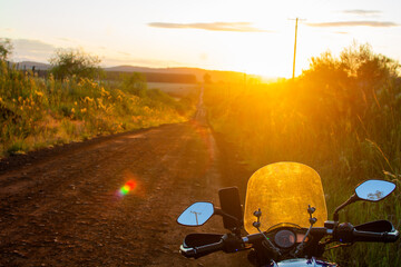 motocicleta en la carretera al amanecer, calle de tierra roja, Argentina