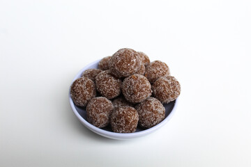 Tamarind candy balls in white bowl. Isolated on white background