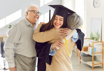 Celebration graduating old happy parents hugging smiling graduate. Parents congratulate their...