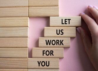 Let us work for you symbol. Wooden blocks with words Let us work for you. Beautiful pink background. Businessman hand. Business and Let us work for you concept. Copy space.
