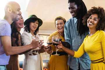 Multi-ethnic group toasts with wine - Happiness and friendship at home - Celebration and diversity concept