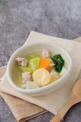 Soup with egg tofu and minced pork in a white oval cup