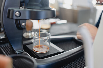 Close up of espresso pouring from coffee machine.