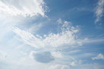 White fluffy clouds in the sky. Blue sky and cloud cover on a sunny summer day. Empty background, copy space