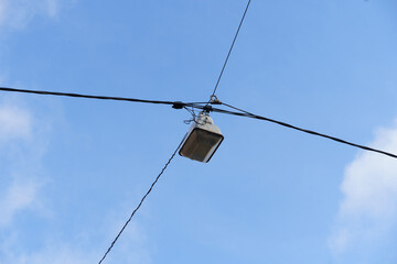 Street Light Hanging From Wire Against Blue Sky