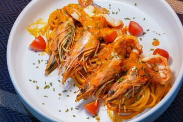 Spicy spaghetti with shrimps in tomato sauce close-up on a plate. top view from above