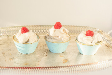 Three ceramic jars with cream and raspberry