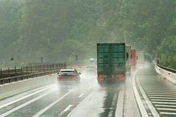 Heavy rain on a highway with cars moving along it