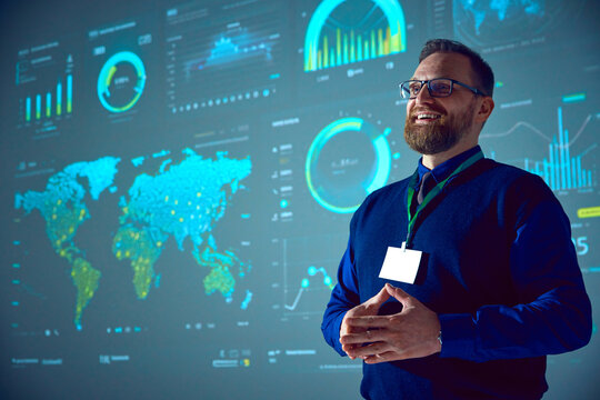 Smiling businessman with glasses presenting analytical data visualizations on large screen. Morning briefings. Concept of business, startup, leadership, personal development courses.