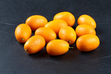Fresh kumquat fruit on dark background