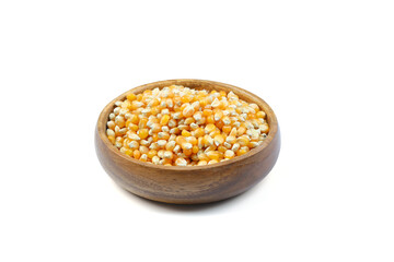Unpopped popcorn in a wooden bowl on white background. A type of corn that expands from the kernel...