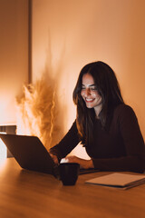Head shot pleasant happy young woman freelancer working on computer at night. Attractive...