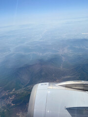 Fototapeta na wymiar Looking at the Beautiful Landscape & Mountains through the window of an aircraft during flight