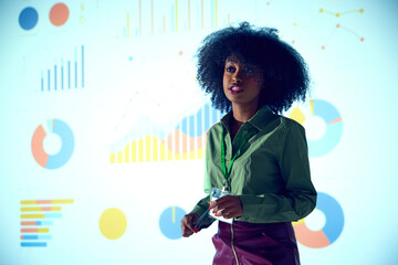 African-American woman, speaker presents statistical data with pointer against projected graph background at business conference. Concept of business, startup, leadership, personal development courses