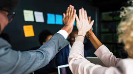 Businessmen high-five each other at a work meeting