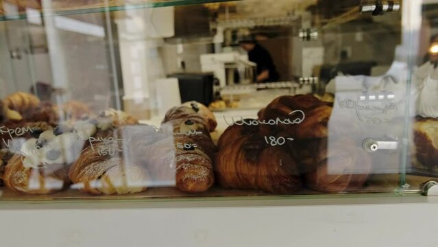 A display case in a coffee shop filled with freshly baked, hot pastries. 