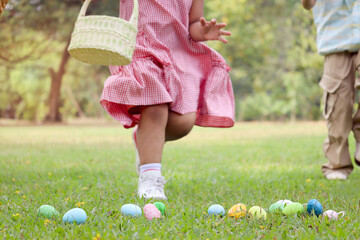 Colorful Easter eggs on green grass backyard with blurred background children with bunny ears...