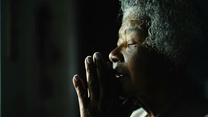 Religious Senior African American woman closing eyes in Prayer by window, close-up profile face of an elderly black lady with gray hair in deep meditation - obrazy, fototapety, plakaty