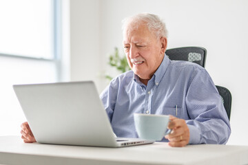 senior men using a laptop while sitting at the office
