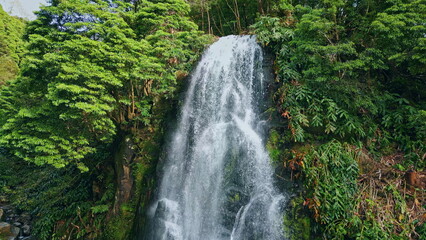 Vivid waterfall falling mountain rocks drone view. Rainforest stream rushing