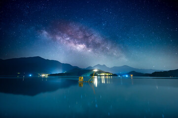 Beautiful view of the Milky Way from the pier on the lakeside of the mountains. Sun Moon Lake is...