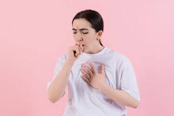 Attractive Caucasian young brunette woman in casual clothes suffers due to cough, cold isolated on...