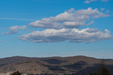 Copy space image of mountains late winter early spring bright day blue sky with some clouds