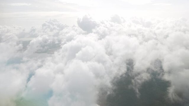blue sky with white fluffy clouds from airplane flight fly over the clouds in a sunny day with cloud moving in summer