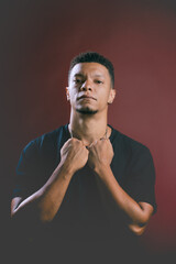 Portrait of serious looking young African American man holding on to neck chain