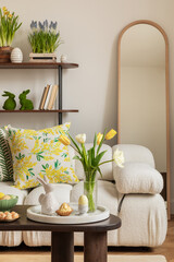 Sunny and design interior of living room with easter decorations, tulips, modular sofa, shelf, pillows and elegant accessories. Home decor. Easter holidays.	
