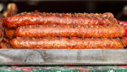 Close-up of fried sausages. Delicious grilled sausage. German grilled Bratwurst sausages at street market. Traditional street food