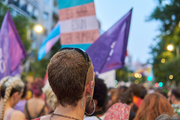 Crowd of people with trans pride flags on a protest for social rights of lgbtiq community at sunset