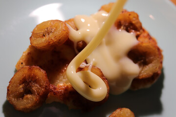 Fried cheesecakes sprinkled with condensed milk and grilled bananas