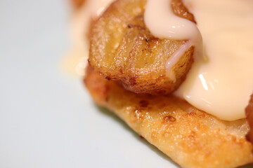 Fried cheesecakes sprinkled with condensed milk and grilled bananas. Delicious background. Macro...