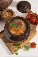 Meat goulash with vegetables in a pot on the kitchen table