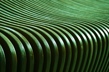 The surface of curved wooden planks, slats. Green boards changing angle and color. Abstract background.