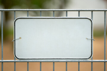  weißes unbeschriftetes Schild an einem Zaun mit Platz für Text