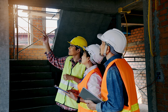 Professional technicians report on the progress of commercial building construction sites to civil engineers
