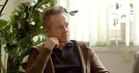 Man nodding his head, indicating attentive listening. Facial expression suggests engagement and...