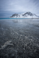 Interesting patterns and textures left by fading ebbs on the Skagsanden beach with the Hustind...