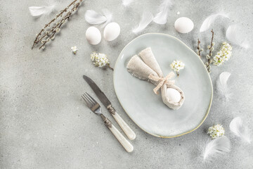 Easter table. Easter holiday table setting with egg in grey napkin Easter Bunny