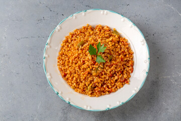 Traditional turkish bulgur pilaf with tomato sause in plate (Turkish name; meyhane pilavi)