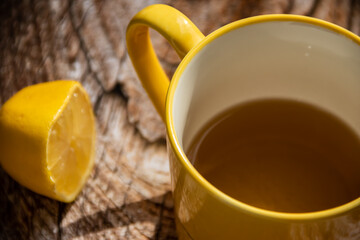 Teapot (French press) with half lemon and teapot at wooden table on the balcony, morning tea time,...