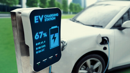 Electric car recharging with EV charger from charging station at public car park. Future innovative...